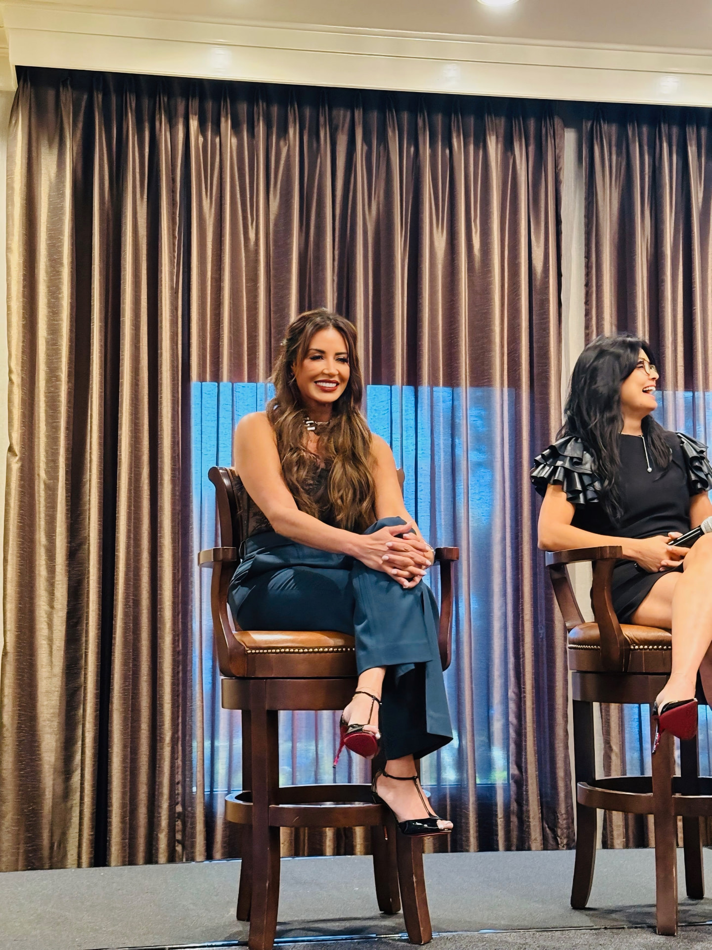 Madeline Ricci speaking on a panel, seated on stage beside another panelist
